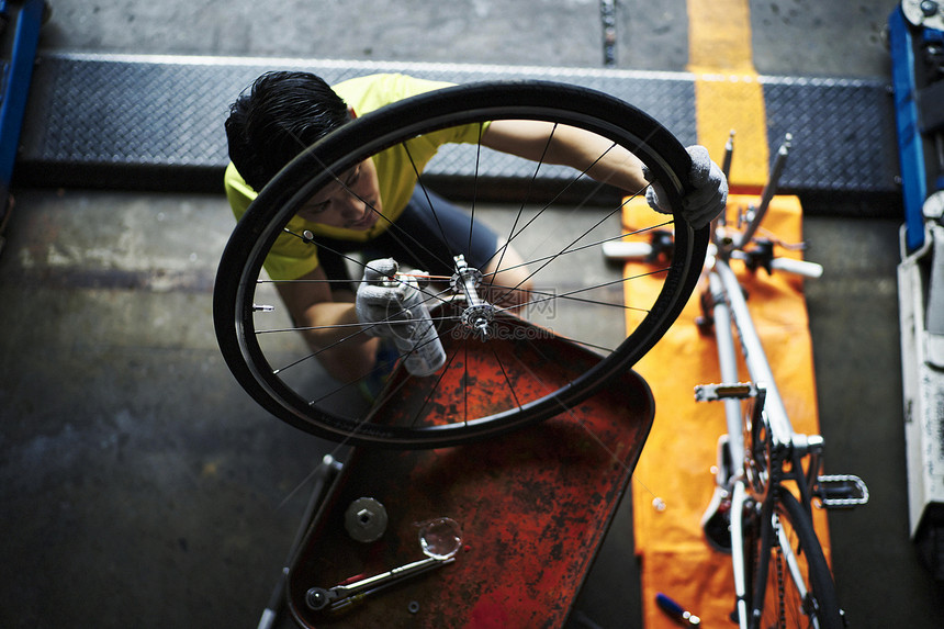 维修自行车轮子的商务男士图片