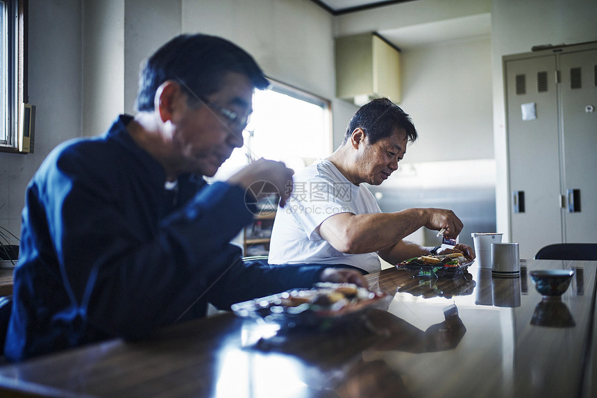 午餐时间吃饭聊天的工厂工作人员图片