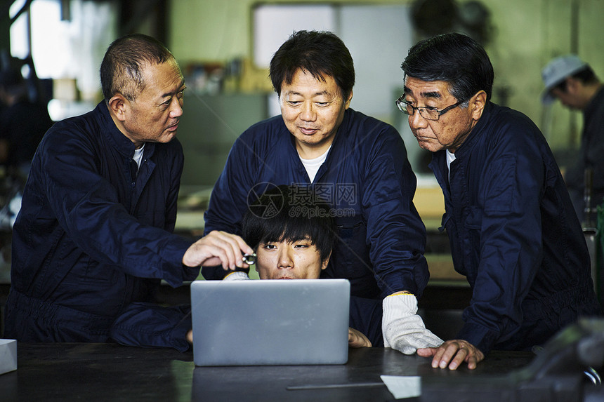 指导年轻人学习工厂技术的老工匠图片