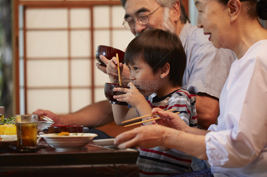 围坐在餐桌前吃饭的家人图片