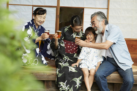 日式房屋中穿和服的女性与孙子祖父喝酒图片