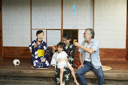 日式房屋中喝酒庆祝的4人图片