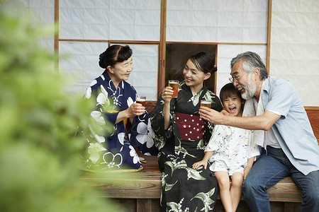 日式房屋中喝饮料乘凉的4人图片