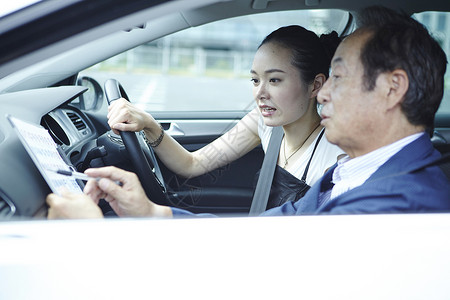 年轻女性在年长男人的指导下学习开车图片