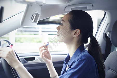汽车座位上化妆的年轻女性高清图片