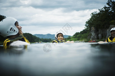 穿着救生衣在水里浮着的年轻人玩高清图片素材