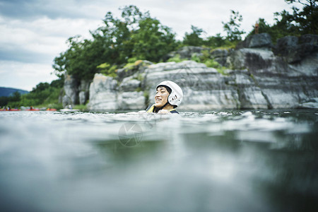 穿着救生衣在水里浮着的年轻人观光客高清图片素材