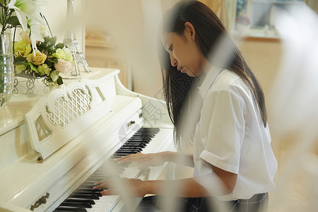 在客厅穿校服的女孩弹钢琴图片