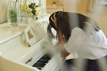 苦恼的弹钢琴的女高中生图片