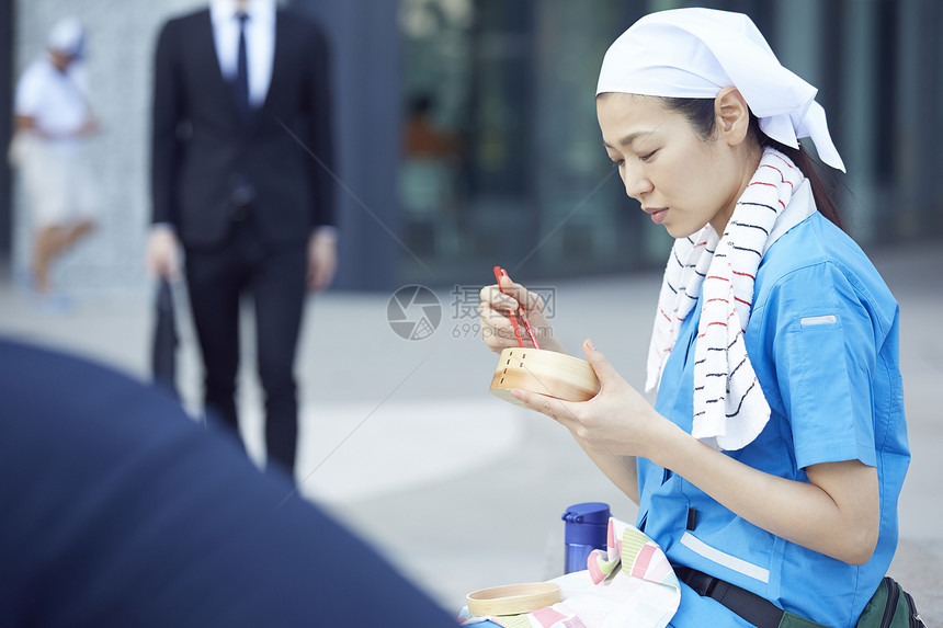 在办公楼下吃午餐的女清洁员图片