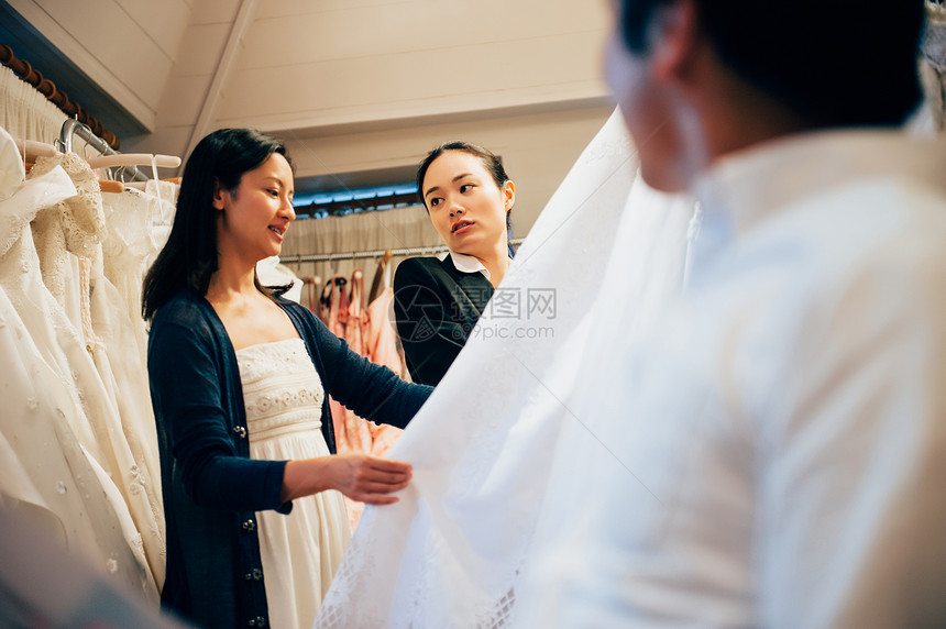 婚礼策划师与新娘挑选婚纱图片