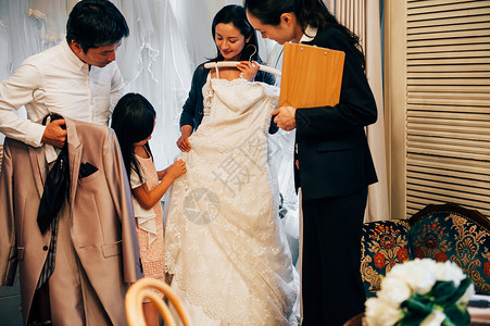 婚礼策划素材挑选婚纱的3人与婚礼策划师背景