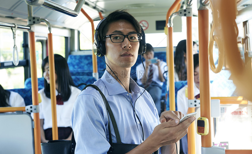  公交车上戴耳机的男性图片