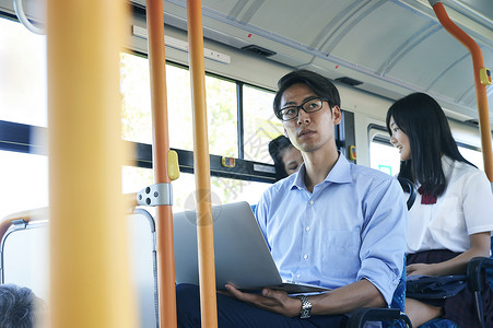  公交车上使用电脑的男性图片