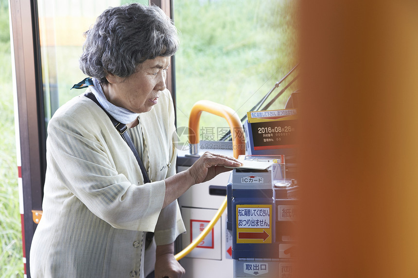 老年女性在公交车上刷卡投币图片