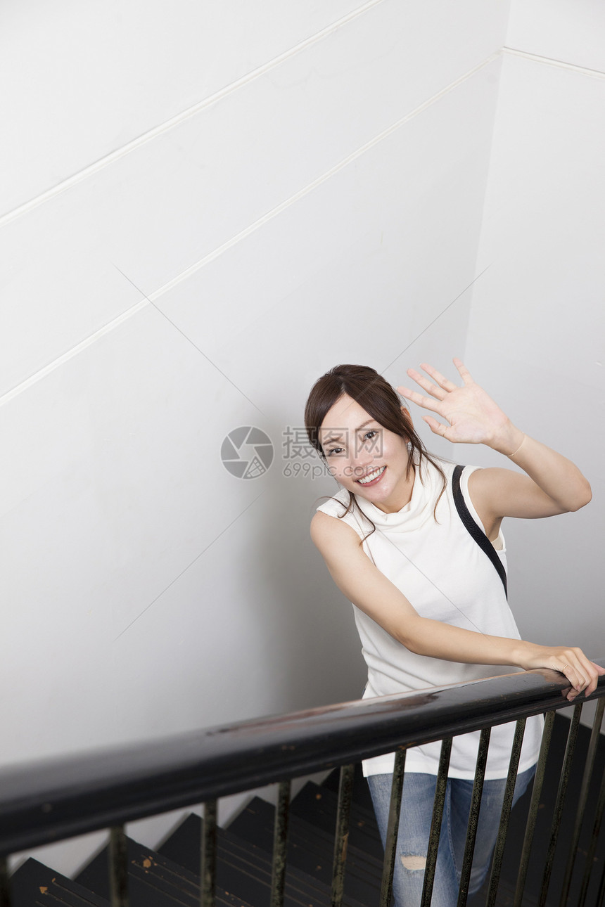 站在楼梯下打招呼的女性图片