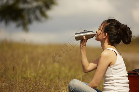 旅途中喝水休息的女性图片