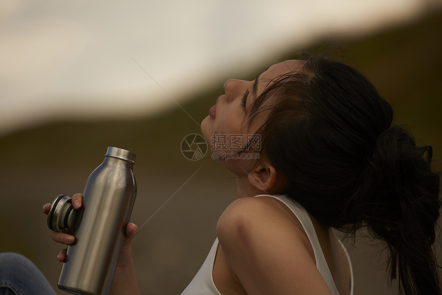旅途中喝水休息的女性图片