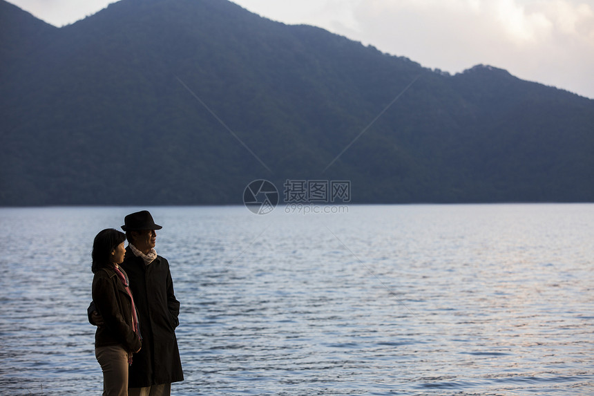  站在海边的一对夫妻看风景图片