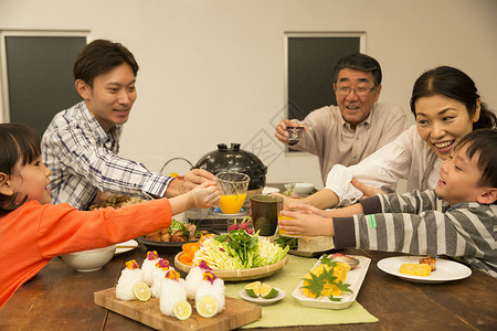 锅里煮好的食物一家三代人享用晚餐背景