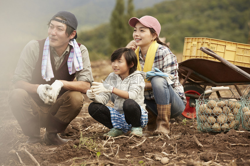 在田地里收完土豆休息的一家人图片