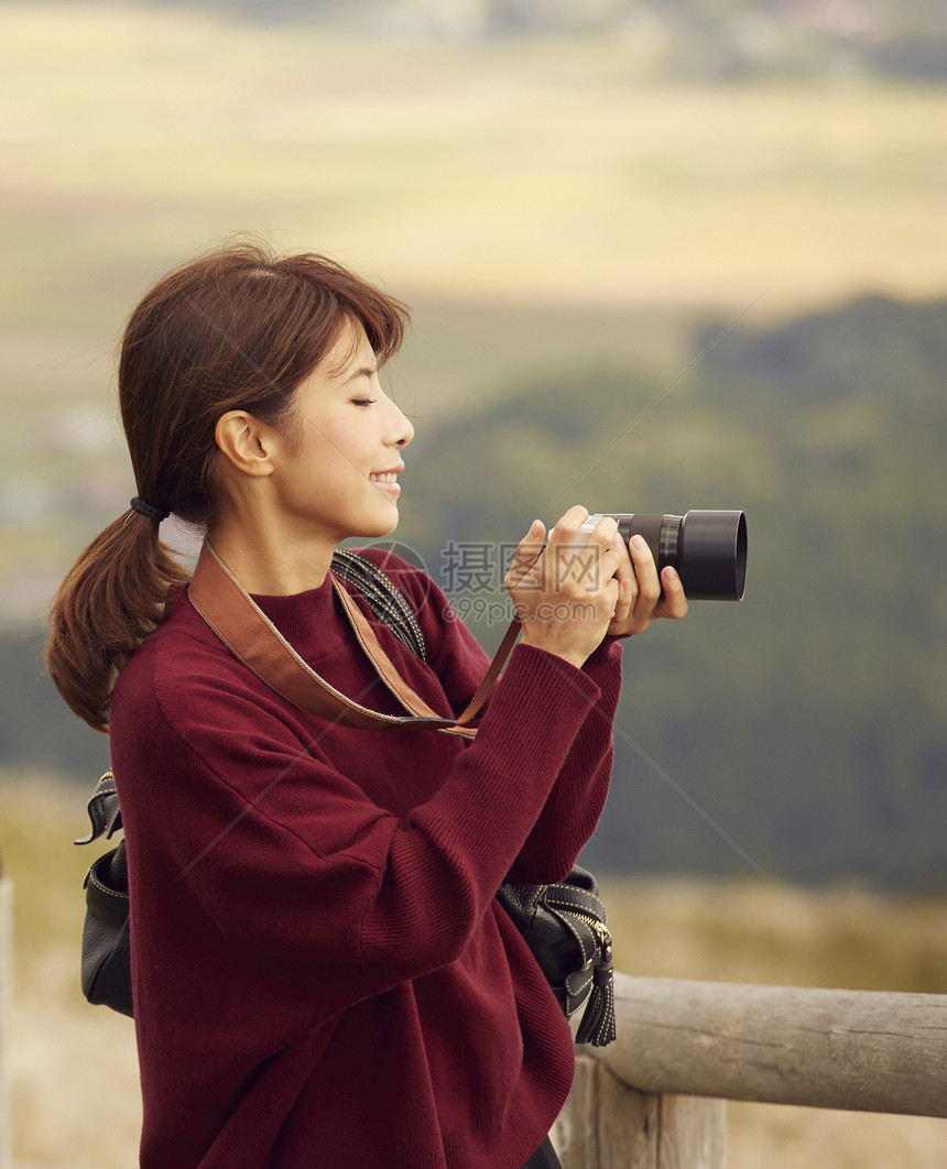 女性青年在户外旅游观光拍照图片