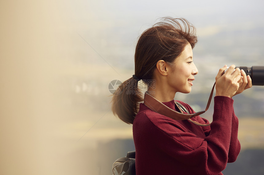 女性青年在户外旅游观光拍照图片