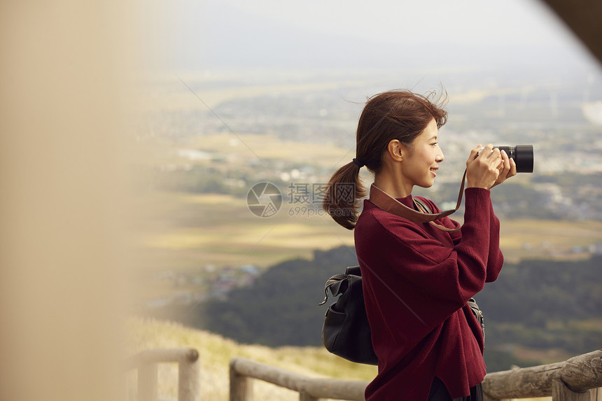 女性青年在户外旅游观光拍照图片