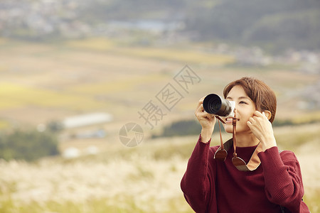 女性青年在户外旅游观光拍照图片