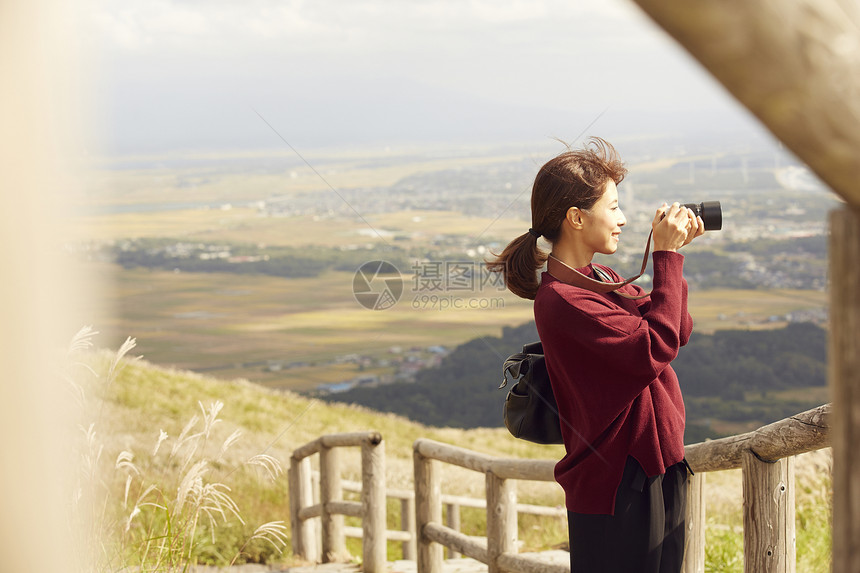 女性青年在户外旅游观光拍照图片