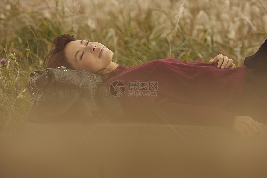 女人躺在野外草地上休息图片