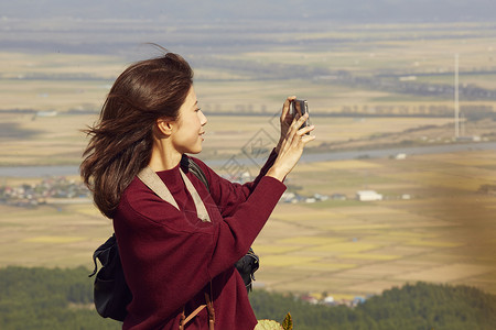 女性青年在户外旅游观光拍照图片