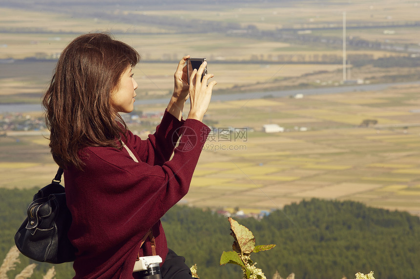 女性青年在户外旅游观光拍照图片