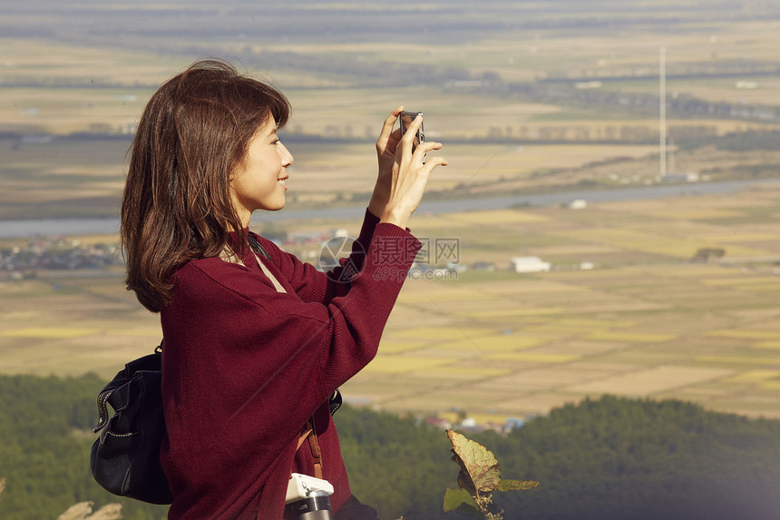 女性青年在户外旅游观光拍照图片