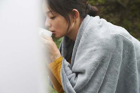 在草地上撑着头的女人在喝水图片