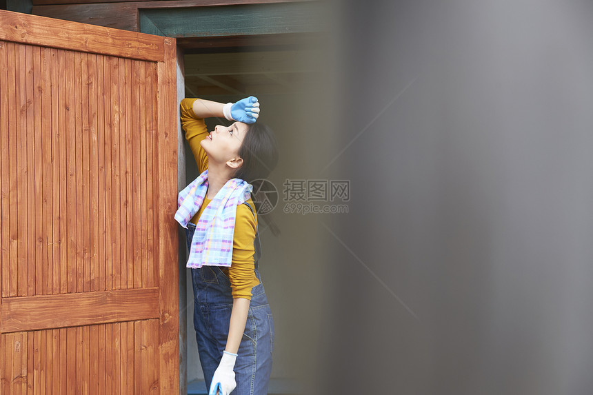 站在木屋门口装修屋子的女孩图片