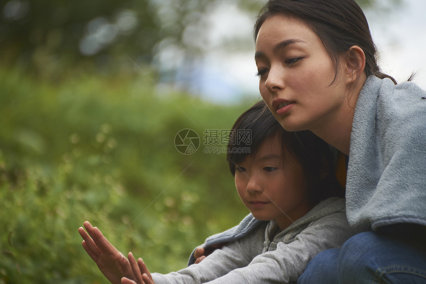 母亲和孩子在户外烤篝火图片