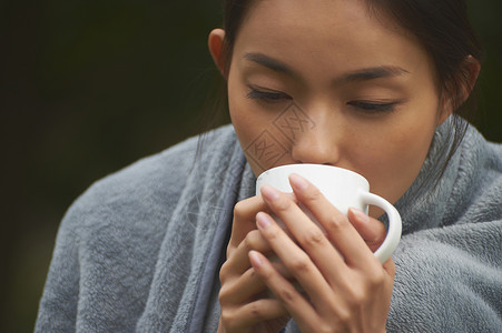 披着毛毯喝咖啡的女性图片