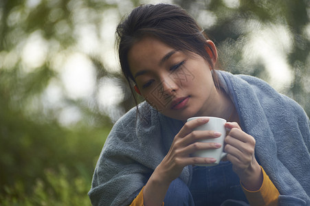 露营时喝咖啡的女性图片