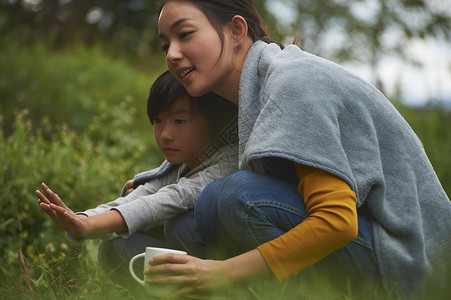 蹲在篝火旁取暖的母子二人图片