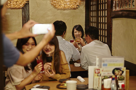 在餐厅喝酒拍照的女性朋友图片
