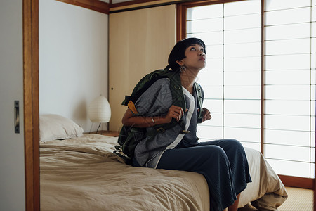 假期出游的女背包客在旅店的形象图片