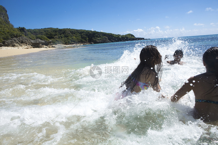 在海滩边游玩的年轻男女图片