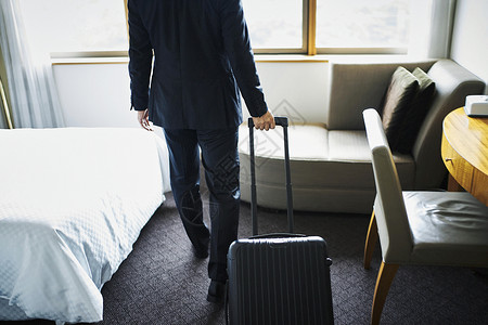 商务男子拎着行李箱入住酒店套装高清图片素材