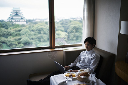 在酒店早餐桌旁工作的商务男子图片