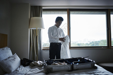 商务男子在酒店整理行李商务酒店高清图片素材