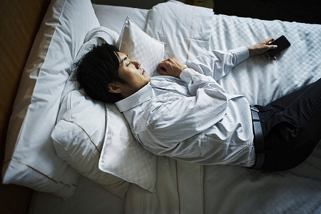 早晨在酒店床上休息的中年男子图片