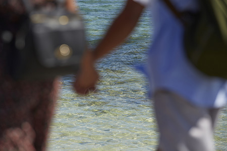 琉球晴天在海边手度假牵着手的情侣背影背景