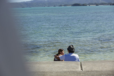  坐在海边聊天的情侣图片