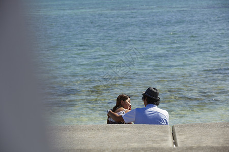   坐在海边聊天的情侣图片
